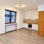 Helle Studioküche mit Fenster und Einbauschrank