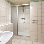 Helles Badezimmer mit Dusche und Waschbecken