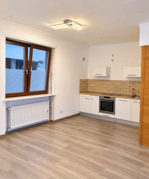 Helle Studioküche mit Fenster und Einbauschrank